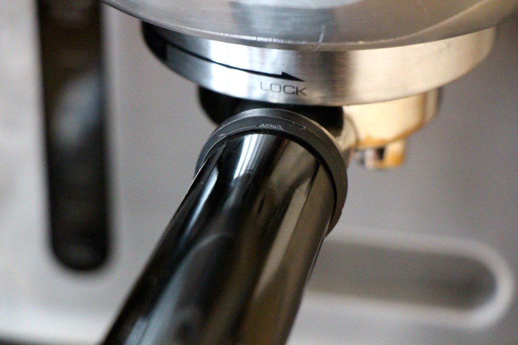 Detalle cercano de una cafetera espresso con el portafiltro colocado